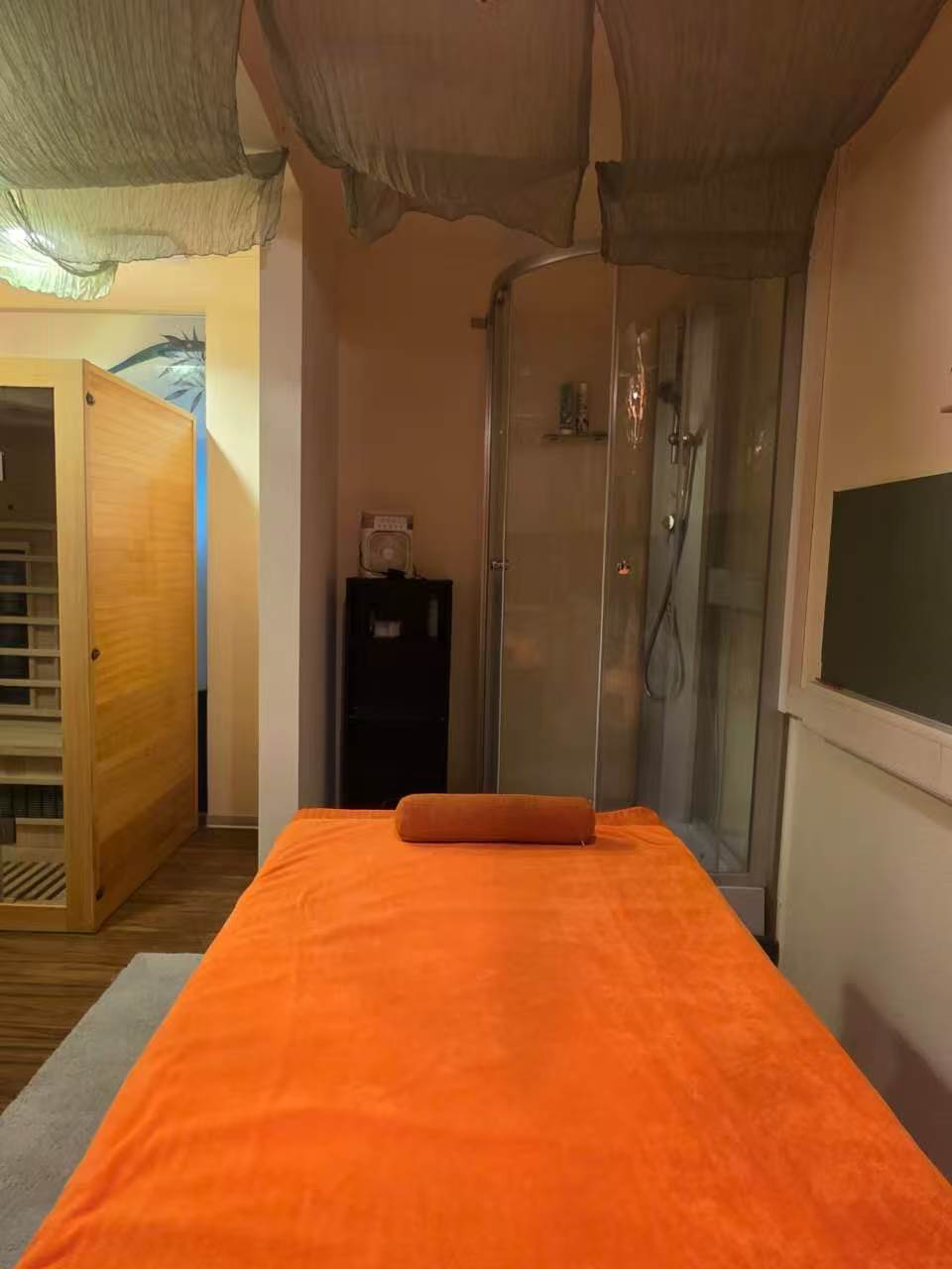 Behandlungsraum mit Infrarot-Kabine, Dusche und Massageliege