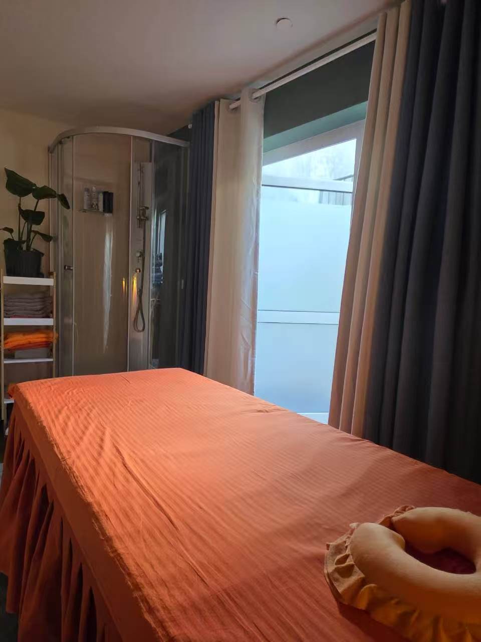Heller Behandlungsraum mit Tageslicht, Dusche und frischen Handtüchern