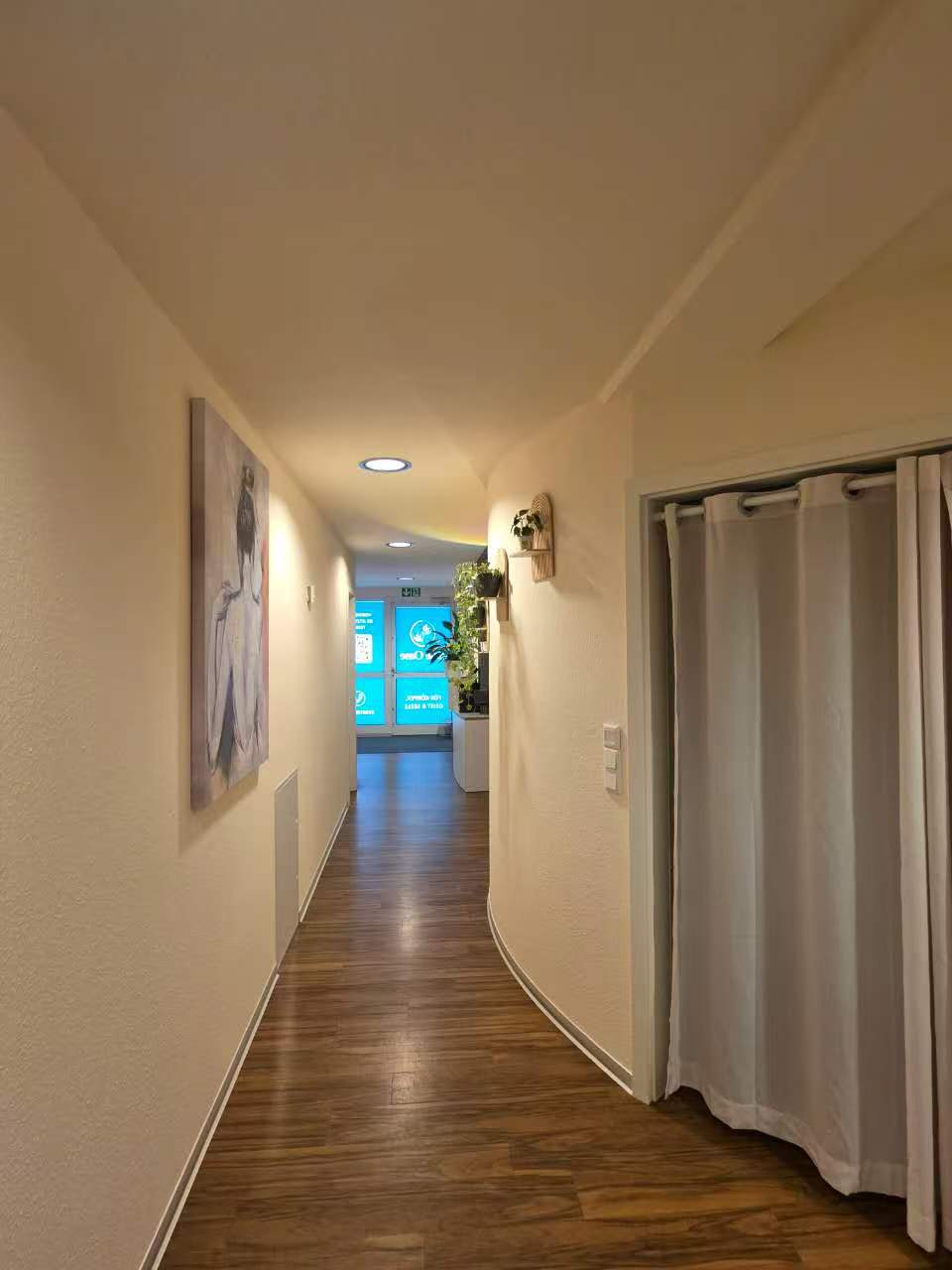 Flur mit Kunstwerk und beleuchtetem Jade Oase Hinweisschild
